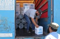 عمال يفرغون شاحنة مساعدات تابعة للأمم المتحدة في سوريا.