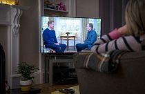 Brit nő nézi a tévében Harry herceg Tom Bradby-nek adott interjúját január 8-án - a herceg később más csatornáknak is nyilatkozott