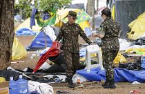 Des soldats aident à nettoyer un campement installé par des partisans de l'ancien président brésilien Jair Bolsonaro devant le quartier général de l'armée à Brasilia