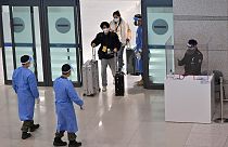 عمال صحيون في كوريا الجنوبية أثناء استقبال وافدين من الصين