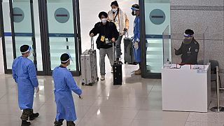 عمال صحيون في كوريا الجنوبية أثناء استقبال وافدين من الصين