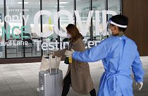 Çin'den gelen bir kadın Güney Kore'deki Incheon Uluslararası Havalimanı'nda Covid-19 test merkezine giriyor