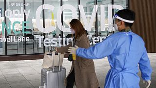 Çin'den gelen bir kadın Güney Kore'deki Incheon Uluslararası Havalimanı'nda Covid-19 test merkezine giriyor