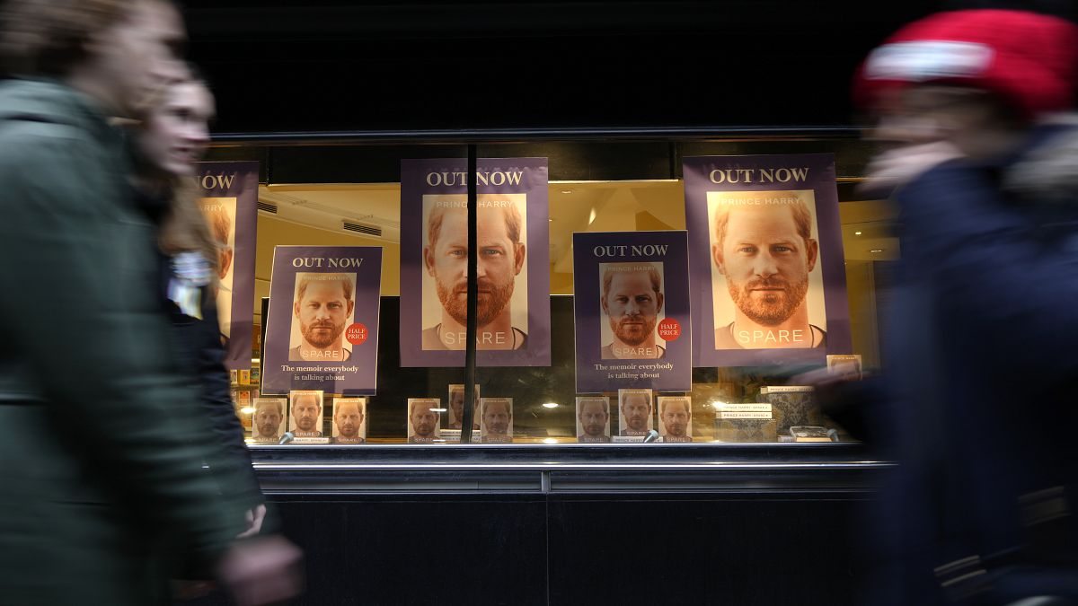 Pedestrians pass a display in the window of a book shop in London on Tuesday. 