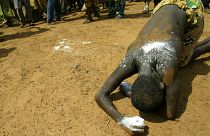 A woman collapses in a trance after being possesed by the voodoo spirits in Ouidah, Benin.