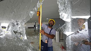 Des ouvriers mesurent les fenêtres brisées du palais de Planalto au lendemain de l'assaut des partisans de Jair Bolsonaro à Brasilia, lundi 9 janvier 2023.
