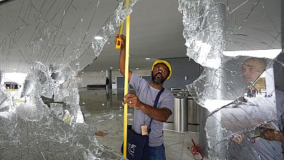 Des ouvriers mesurent les fenêtres brisées du palais de Planalto au lendemain de l'assaut des partisans de Jair Bolsonaro à Brasilia, lundi 9 janvier 2023. 