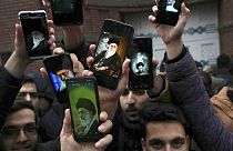 Manifestantes exibem imagens nos telemóveis do líder supremo do Irão, Ayatollah Khamenei, em Teerão
