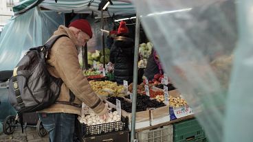 A man shops at an outdoor vegetable stand at the Hala Mirowska market in Warsaw. A man shops at an outdoor vegetable stand at the Hala Mirowska market in Warsaw.
