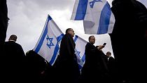 Israeli lawyers wave the national flag during a protest against the government's plans to overhaul the country's legal system outside the District Court in Tel Aviv, Israel.