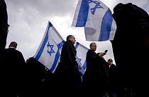 Israeli lawyers wave the national flag during a protest against the government's plans to overhaul the country's legal system outside the District Court in Tel Aviv, Israel.