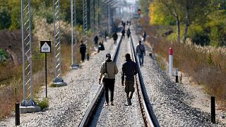 Migrants walk on the railway tracks near a border line between Serbia and Hungary, near village of Horgos, Serbia, Oct. 20, 2022. 