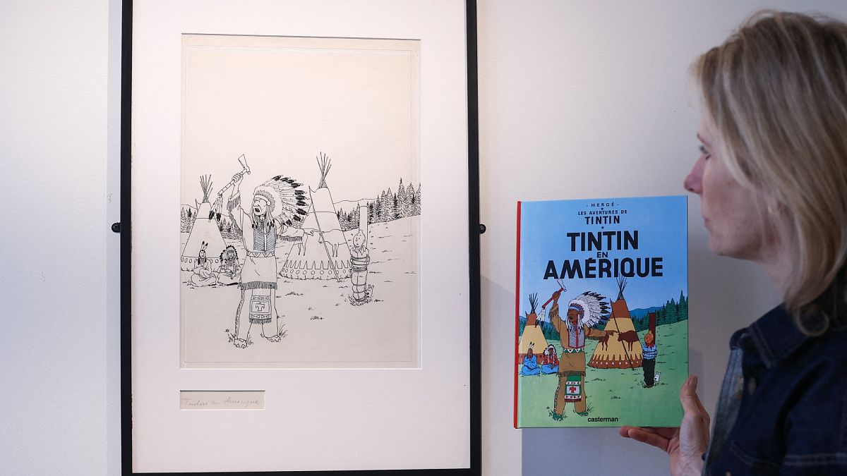 مديرة "آر كوريال" في بلجيكا  فينسيان دو ترو تقف أمام الرسم الأصلي لغلاف مجلّد قصة "تان تان في الولايات المتحدة" الذي أصدر عام 1942.