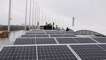 Workers mount solar panels on the roof of the Olympic Stadium or Olympiastadion in Berlin, Germany