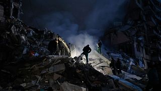 Emergency workers clear the rubble after a Russian rocket hit a multistory building leaving many people under debris in Dnipro