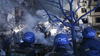 Keresik a romok alatt rekedt embereket az ukrajnai Dnyipróban, 2023. január 14-én