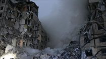 Des secouristes fouillent les décombres après le tir d'un missile russe sur un immeuble à Dnipro, en Ukraine, samedi 14 janvier 2023.