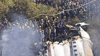 Nepalese rescue workers and civilians gather around the wreckage of a passenger plane that crashed in Pokhara, Nepal, Sunday, Jan. 15, 2023. . 