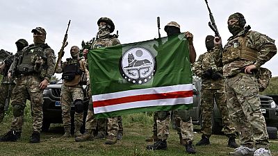 The Dzhokhar Dudayev Chechen volunteer battalion hold the flag of the Chechen Republic of Ichkeria during a training session in the Kyiv region on August 27, 2022