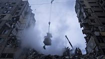 Rettungskräfte räumen die Trümmer eines Wohnhauses, das bei einem russischen Raketenangriff auf ein Wohnviertel in Dnipro zerstört worden war