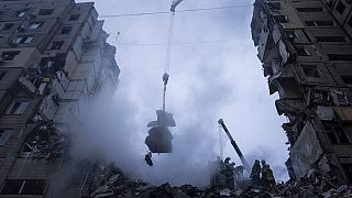 Rettungskräfte räumen die Trümmer eines Wohnhauses, das bei einem russischen Raketenangriff auf ein Wohnviertel in Dnipro zerstört worden war