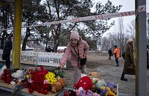 سيدة أوكرانية تضع الزهور للذين قتلوا في هجوم صاروخي روسي على مبنى سكني في مدينة دنيبرو الجنوبية الشرقية ، أوكرانيا