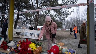 سيدة أوكرانية تضع الزهور للذين قتلوا في هجوم صاروخي روسي على مبنى سكني في مدينة دنيبرو الجنوبية الشرقية ، أوكرانيا