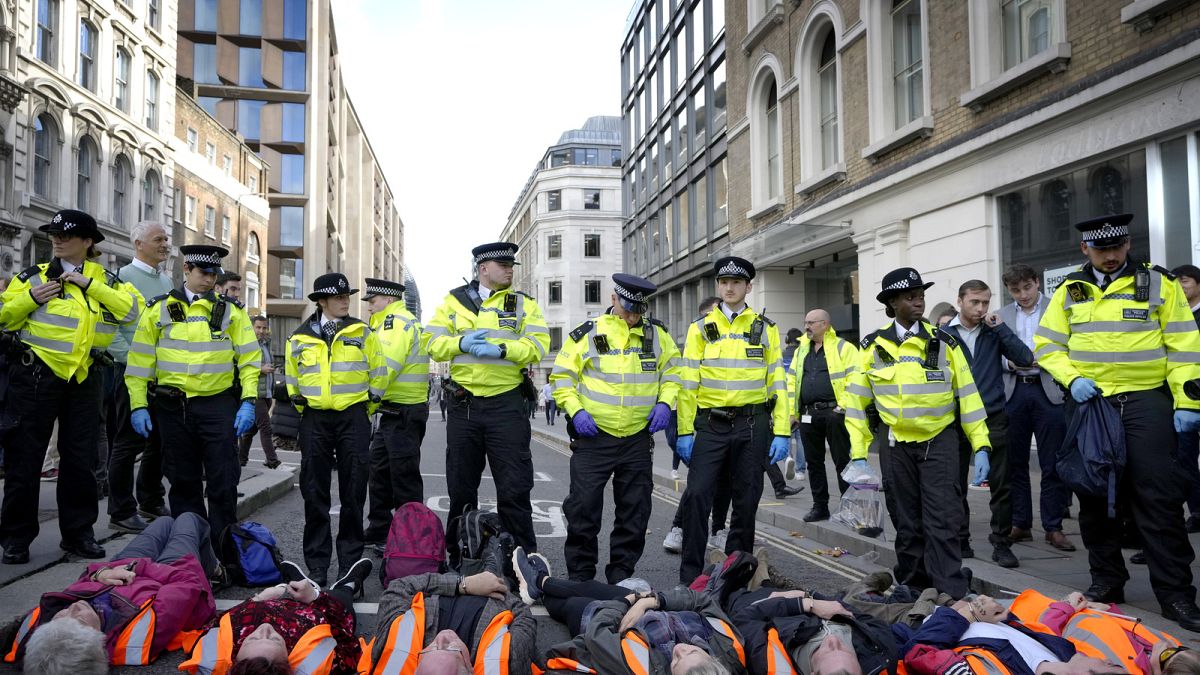 Handcuffed activisits from the group Just Stop Oil lie on the road as they are arrested after they blocked a road in London. Thursday, 27 October 2022