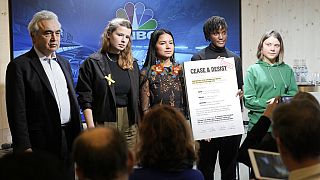 Climate activists Greta Thunberg, Vanessa Nakate, Helena Gualinga and Luisa Neubauer (r-l) stand together with a notice to Fossil Fuel CEOs, beside Fatih Birol, IEA chief.