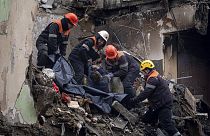 Спасатели переносят тело мужчины, погибшего в результате российского ракетного удара по многоквартирному дому в юго-восточном городе Днепр /Украина