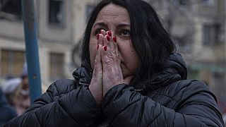 A woman reacts looking at the damage caused to an apartment building that was destroyed in a Russian rocket attack in  Dnipro, Ukraine, Sunday, Jan. 15, 2023.
