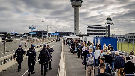 Travelers queue outside Schiphol airport, on September 13, 2022, after Schiphol Airport asked a number of airlines to cancel flights due to a shortage of security personnel.