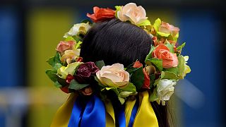 A woman with traditional Ukranian hair decoration takes part at the celebration for the Ukraine Independence day at a celebration in Chichester, south England, 27 August 2022