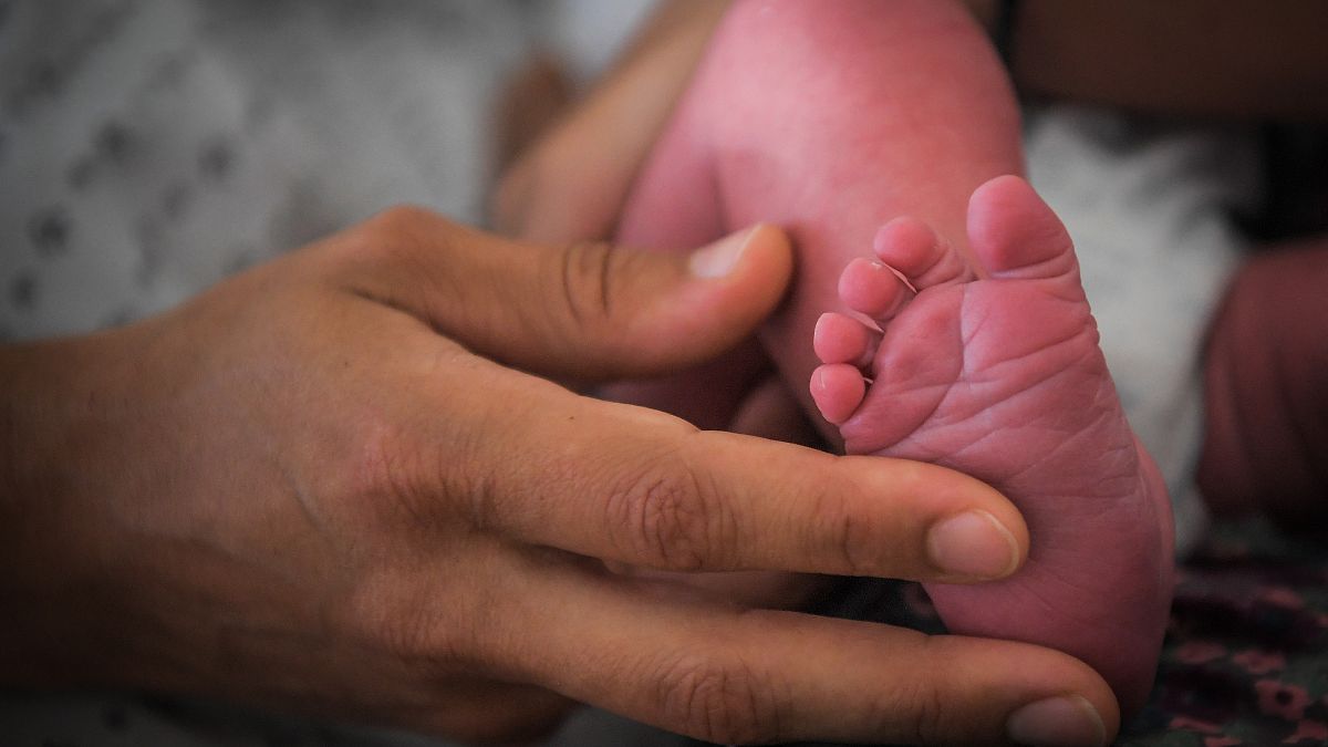 Édesanya tartja újszülöttje lábát a franciaországi Lille kórházában, 2018 júliusában