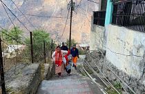 Personnel from disaster response brought in for evacuations from crumbling buildings walk on the steps of Joshimath, India.