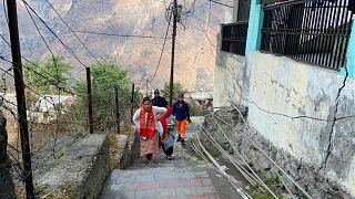 Personnel from disaster response brought in for evacuations from crumbling buildings walk on the steps of Joshimath, India.