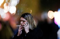 A woman smokes a cigarette outside a restaurant, before smoking was banned in public spaces according to a reform of the Mexican government's regulation.