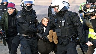Police officers carry Swedish climate activist Greta Thunberg away from the edge during protest action after the clearance of Luetzerath, Germany, Jan. 17, 2023