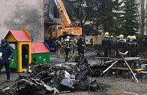 Firefighters work near the site where a helicopter crashed near Kyiv killing 18 people, including interior minister.18 January 2023