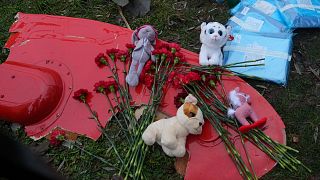 زهور وألعاب موضوعة على قطعة من طائرة هليكوبتر تحطمت بالقربمن روضة أطفال في بروفاري، في ضواحي كييف، أوكرانيا، الأربعاء، 18 يناير/كانون الثاني 2023.