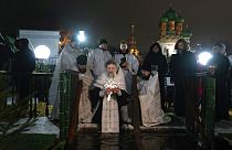 Ein russisch-orthodoxer Priester segnet das eiskalte Wasser während Epiphanias nahe der Dreifaltigkeitskirche in Moskau, 19.1.2023