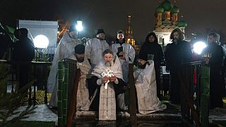 Ein russisch-orthodoxer Priester segnet das eiskalte Wasser während Epiphanias nahe der Dreifaltigkeitskirche in Moskau, 19.1.2023