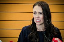 New Zealand Prime Minister Jacinda Ardern grimaces as she announces her resignation at a press conference in Napier, New Zealand.