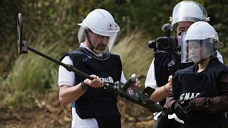 A Ukrainian deminer holds a mine detector as he listens to a Cambodia Mine Action Centre expert during training in Preytotoeung village, 19 January 2023