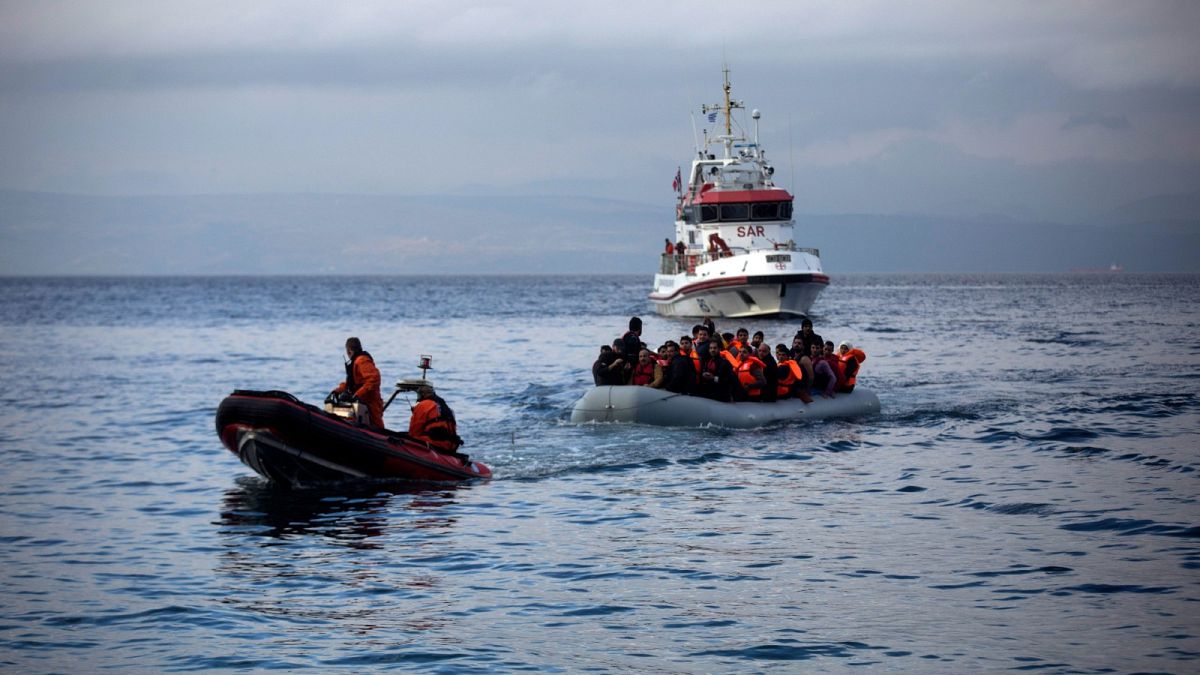 Officers of the EU border security agency, Frontex, pull a dinghy with migrants to Skala Sikaminias village on the northeastern Greek island of Lesbos, Oct. 21, 2015.