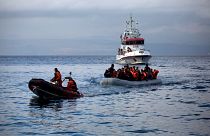 Officers of the EU border security agency, Frontex, pull a dinghy with migrants to Skala Sikaminias village on the northeastern Greek island of Lesbos, Oct. 21, 2015.
