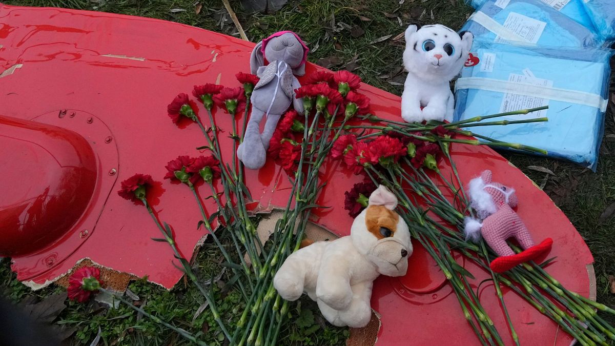 Flowers and toys are placed on a fragment of a helicopter that crashed at a kindergarten in Brovary, in the outskirts of Kyiv, Ukraine