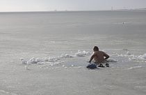 Un homme plonge dans la mer d'Azov, le 19 janvier 2023, pour l'Épiphanie