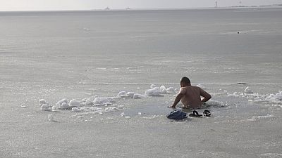 Un homme plonge dans la mer d'Azov, le 19 janvier 2023, pour l'Épiphanie