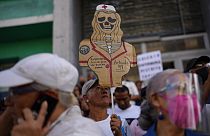 Un manifestante sostiene un esqueleto de cartón con el mensaje: "Las enfermeras luchan por un salario digno" durante una protesta de sanitarios públicos en Caracas, Venezuela.